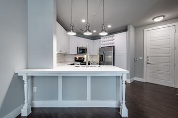 A kitchen with white cabinets and a white island with a counter.